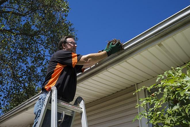 repairman sealing and reattaching a loose and sagging gutter in Great Lakes